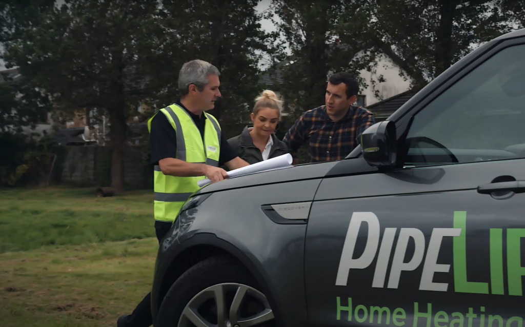 Pipelife representative chatting with a couple in front of a Pipelife branded vehicle