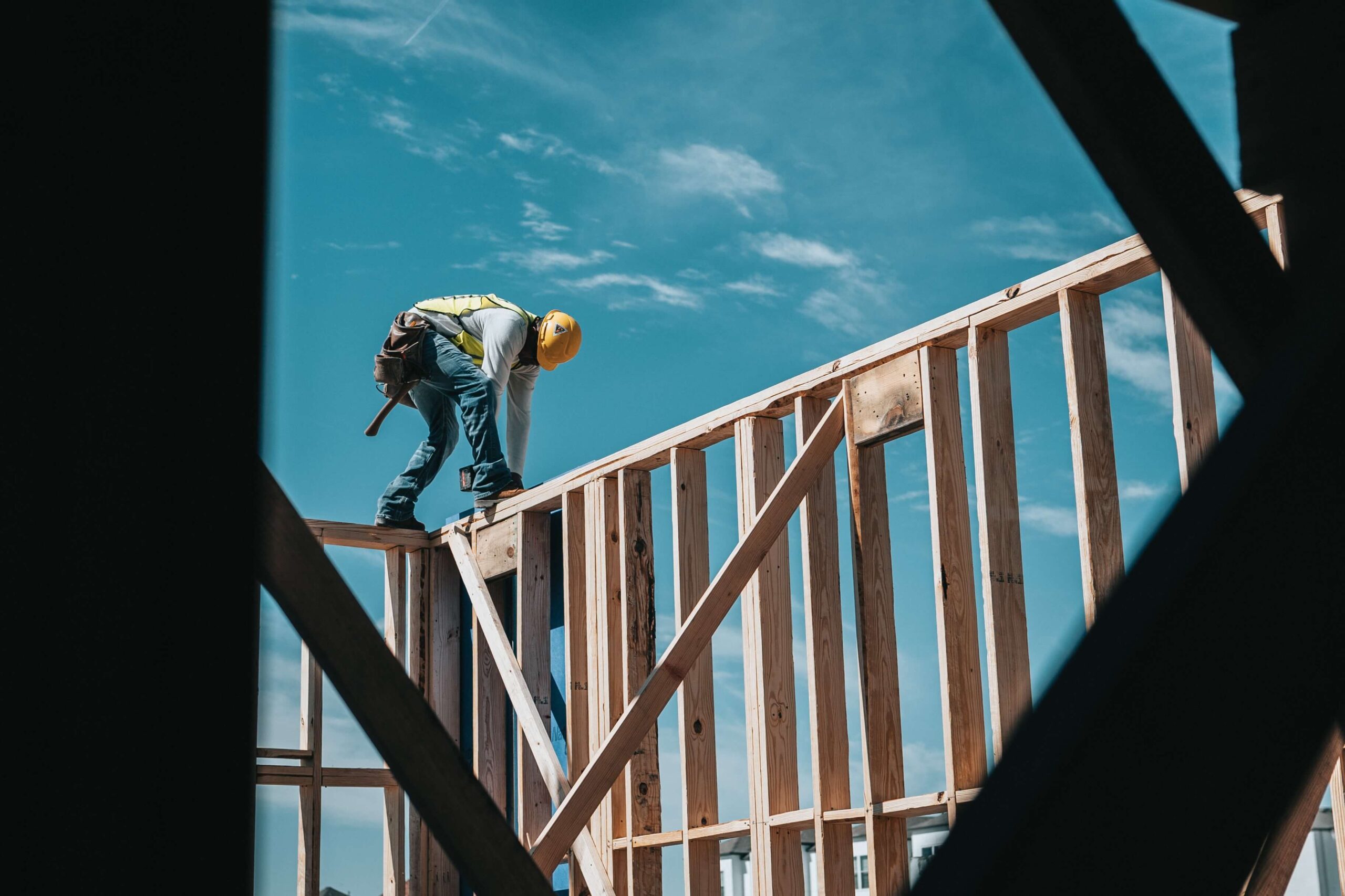 Construction worker completing work on wooden frame structure