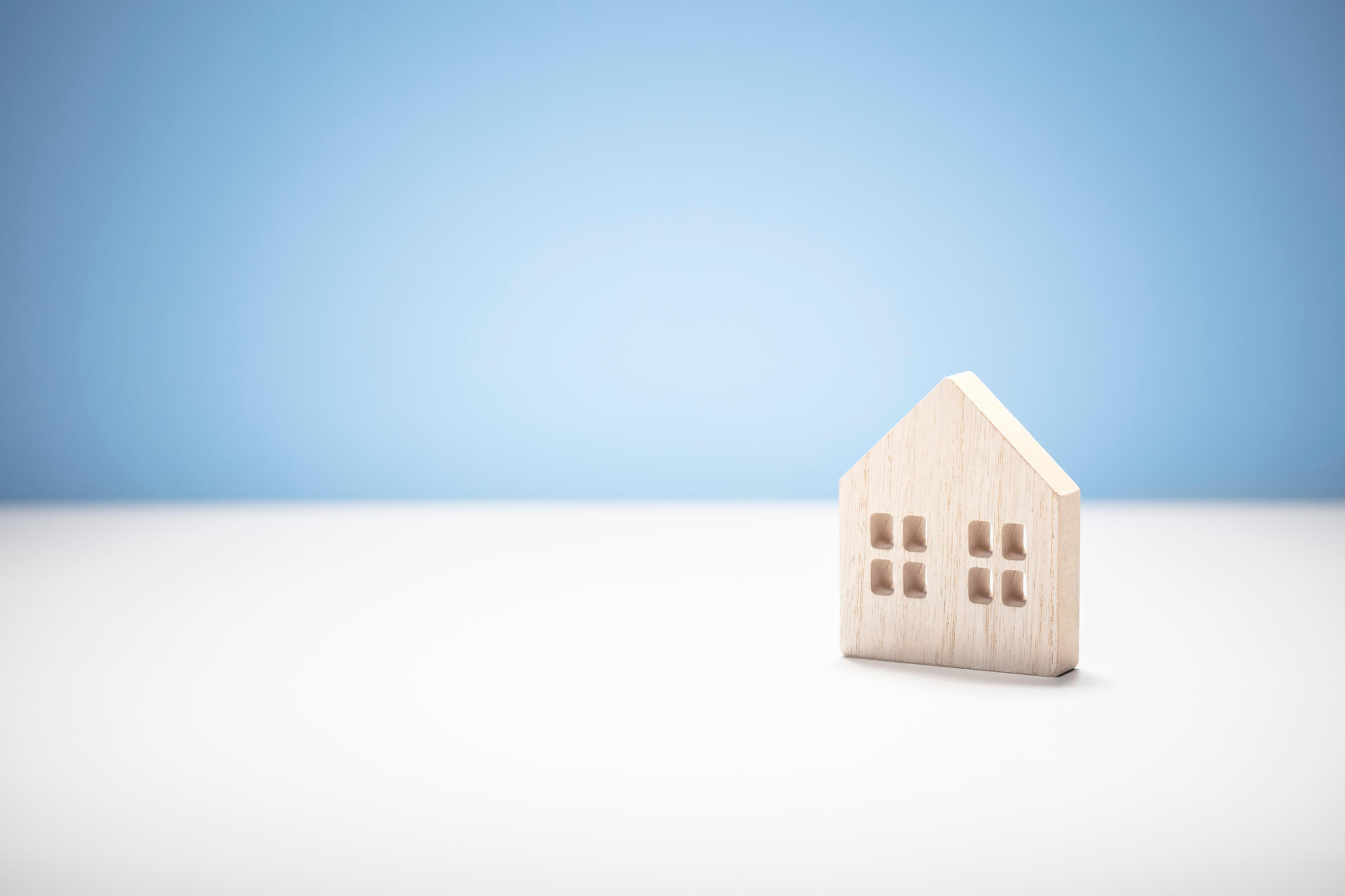 wooden model house on blue and white background