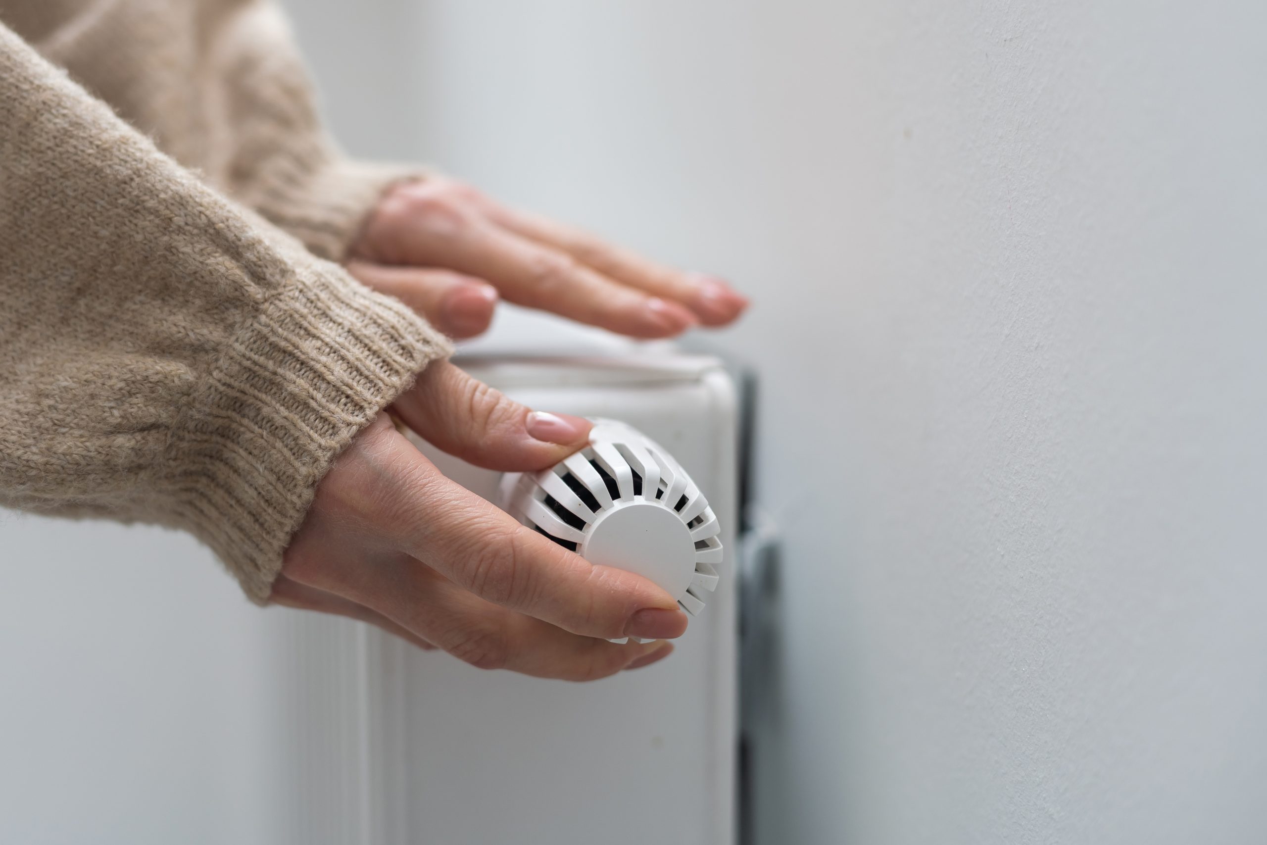 Woman holding temperature knob of radiator