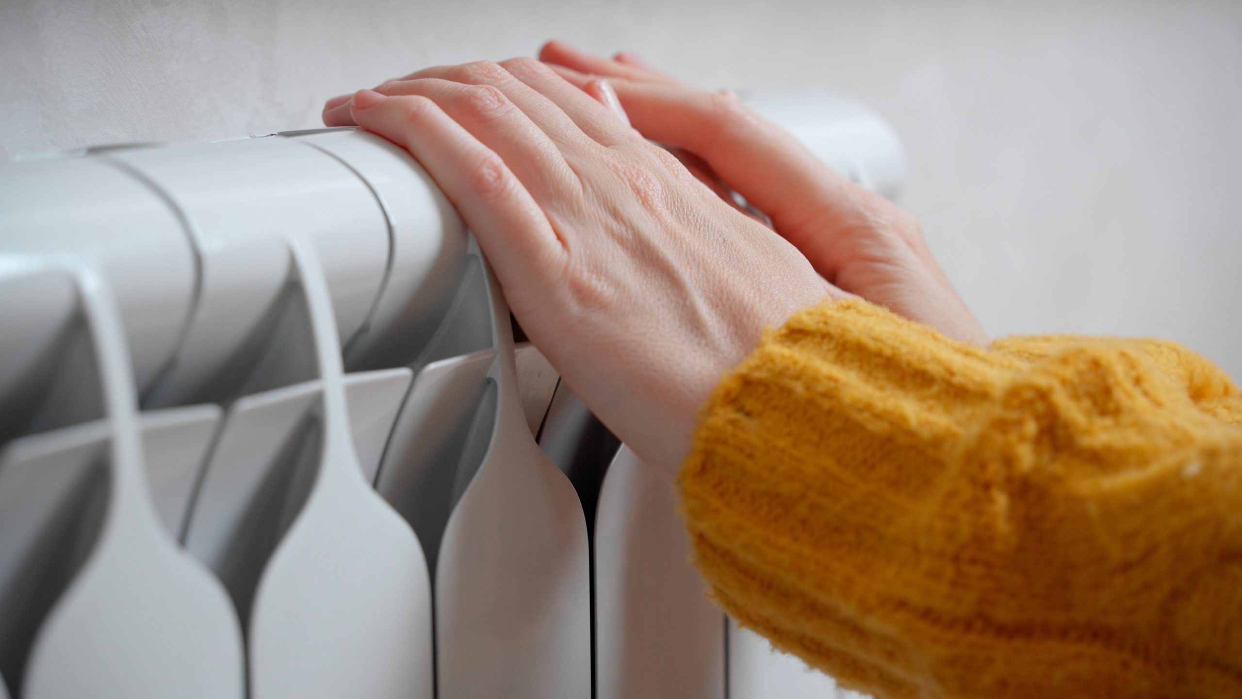 hands touching an aluminium radiator