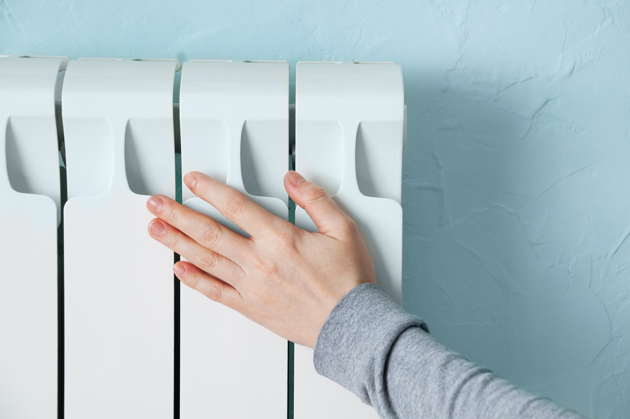 person touches radiator with hand
