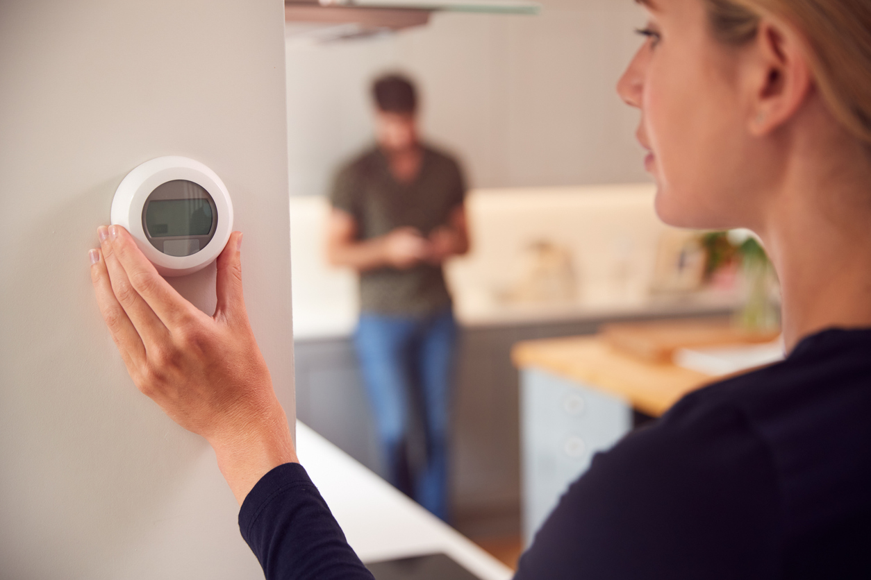 woman adjusting smart heating controls